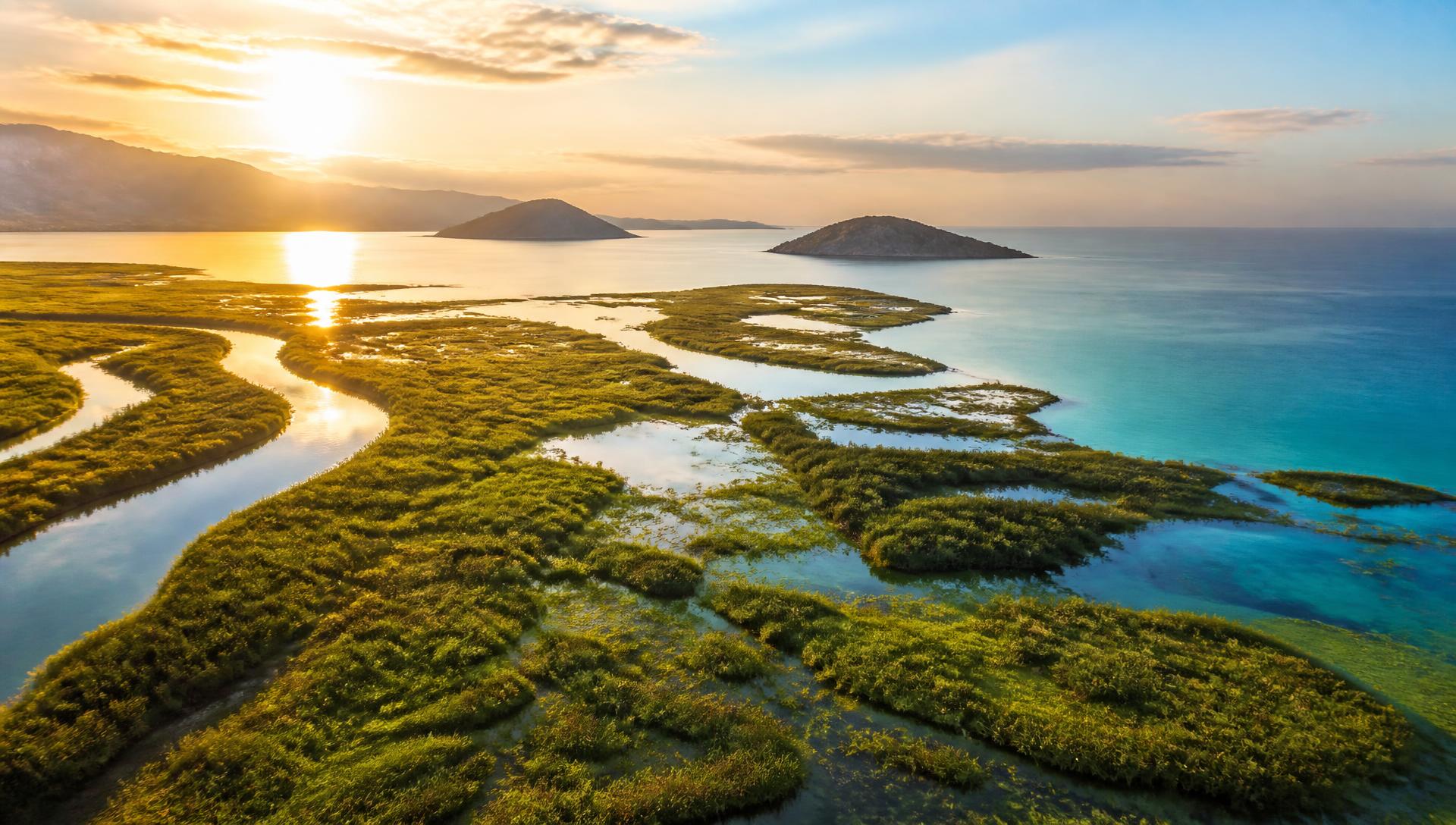 Aerial view of a Mediterranean river delta meeting the sea